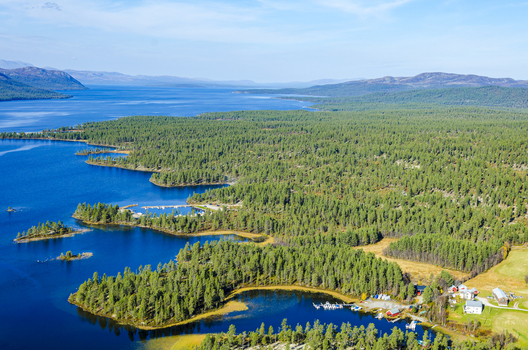 Aerial view of Femund lake surrounded by dense pine forests and mountainous terrain in Norway. Aerial view of Femund lake surrounded by dense pine forests and mountainous terrain in Norway.