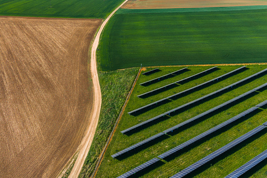 Aerial view of a solar farm installed in a green field next to a dirt path and agricultural land in Kyjov South Moravian Region Czechia.