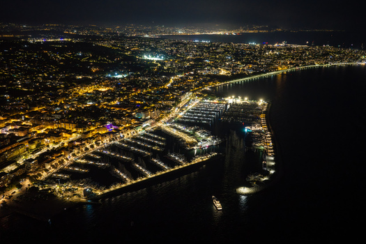 Aerial view of Port Vauban at night featuring illuminated yachts in the marina and city lights along the coastline in Antibes Provence Alpes Cote d Azur France. Aerial view of Port Vauban at night featuring illuminated yachts in the marina and city lights along the coastline in Antibes Provence Alpes Cote d Azur France.