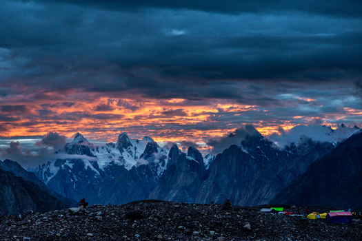 View of Concordia Campsite at sunset with dramatic clouds over the Karakoram mountain peaks in Concordia Gilgit Baltistan Pakistan.