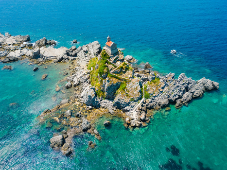 Aerial view of St. Nedjelja Church perched on a rocky islet surrounded by the turquoise waters of the Adriatic Sea near Petrovac Montenegro. Aerial view of St. Nedjelja Church perched on a rocky islet surrounded by the turquoise waters of the Adriatic Sea near Petrovac Montenegro.