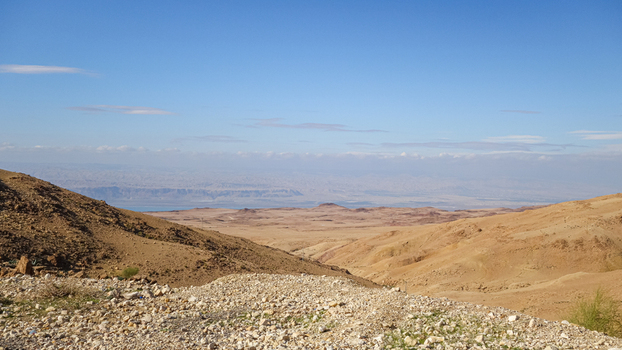 View of the arid desert landscape near Wadi Musa with rolling hills rocky terrain and a clear blue sky in the background Wadi Musa Ma an Governorate Jordan. View of the arid desert landscape near Wadi Musa with rolling hills rocky terrain and a clear blue sky in the background Wadi Musa Ma an Governorate Jordan.