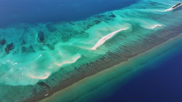 Aerial view of tropical coral reefs and sandbars in Maldives.