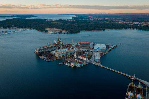 Aerial view of Uljanik Shipyard with industrial cranes ships under construction and docks surrounded by the Adriatic Sea in Pula Croatia. Aerial view of Uljanik Shipyard with industrial cranes ships under construction and docks surrounded by the Adriatic Sea in Pula Croatia.