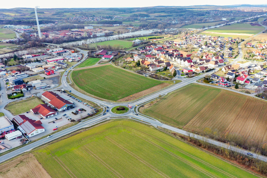 Aerial view of the town of Buttenheim featuring a roundabout residential houses green fields and an industrial area near the river in Buttenheim Bavaria Germany. Aerial view of the town of Buttenheim featuring a roundabout residential houses green fields and an industrial area near the river in Buttenheim Bavaria Germany.