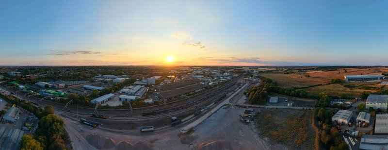 Aerial view of Wellingborough sidings freight terminal with railway tracks industrial buildings and landscape under sunset light in Wellingborough England United Kingdom. Aerial view of Wellingborough sidings freight terminal with railway tracks industrial buildings and landscape under sunset light in Wellingborough England United Kingdom.