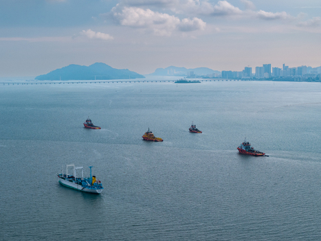 George Town Malaysia 22 September 2026 Aerial view of several ships navigating the calm waters of the Penang Strait with the Penang Bridge and distant city skyline. George Town Malaysia 22 September 2026 Aerial view of several ships navigating the calm waters of the Penang Strait with the Penang Bridge and distant city skyline.