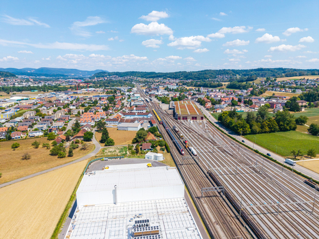 Aerial view of Daniken train station with multiple railway tracks industrial buildings and surrounding town landscape in Daniken Solothurn Switzerland.