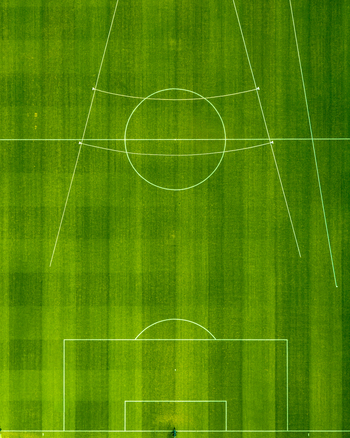 Aerial view of the athletic stadium soccer field with white pitch markings on vibrant green grass in Chorzow Silesian Voivodeship Poland.