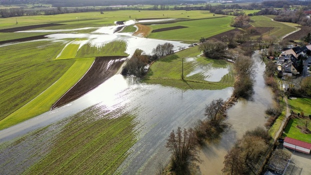 Aerial view of flooded agricultural fields and a swollen river flowing through the rural landscape under bright sunlight Forchheim Bavaria Germany. Aerial view of flooded agricultural fields and a swollen river flowing through the rural landscape under bright sunlight Forchheim Bavaria Germany.