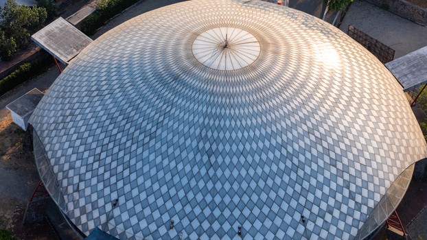 Aerial view of a large dome with a complex geometric diamond pattern illuminated by soft sunlight in Cilacap Central Java Indonesia. Aerial view of a large dome with a complex geometric diamond pattern illuminated by soft sunlight in Cilacap Central Java Indonesia.
