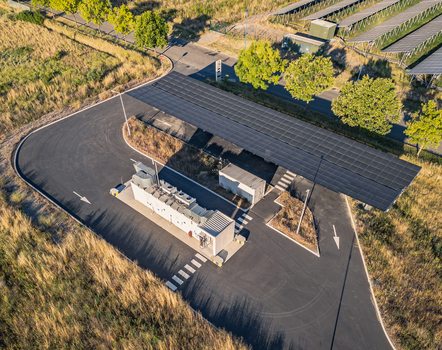 Aerial view of a Battery Energy Storage System and solar photovoltaic carport for renewable energy storage and electric mobility in Le Pouzin Auvergne Rhone Alpes France. Aerial view of a Battery Energy Storage System and solar photovoltaic carport for renewable energy storage and electric mobility in Le Pouzin Auvergne Rhone Alpes France.
