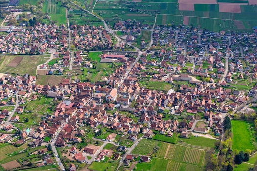 Aerial view of quaint rooftops nestled amidst the patchwork greenery a symphony of rustic charm Kintzheim Grand Est France.