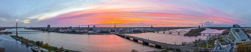 Aerial view of the Riga skyline at sunset featuring the Daugava River historic architecture and bridges in Riga Latvia.