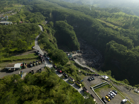 Aerial view of Tambang Pasir Merapi Kali Gendol Sand Mine with trucks on a road and excavators in a ravine in Kecamatan Cangkringan Daerah Istimewa Yogyakarta Indonesia. Aerial view of Tambang Pasir Merapi Kali Gendol Sand Mine with trucks on a road and excavators in a ravine in Kecamatan Cangkringan Daerah Istimewa Yogyakarta Indonesia.