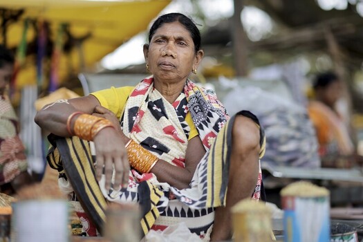 Odisha India 26 March 2026 View of a woman with a shawl draped around her shoulders sitting cross legged amidst the vibrant chaos of a local market stall. Odisha India 26 March 2026 View of a woman with a shawl draped around her shoulders sitting cross legged amidst the vibrant chaos of a local market stall.