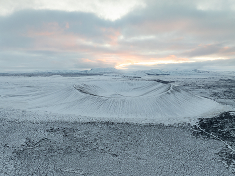 Aerial view of Hverfjall crater covered in snow under a dramatic cloudy sky in Thingeyjarsveit Iceland. Aerial view of Hverfjall crater covered in snow under a dramatic cloudy sky in Thingeyjarsveit Iceland.