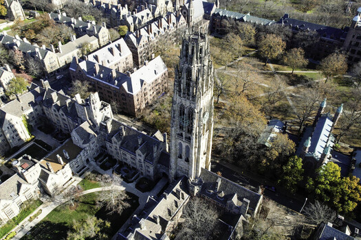 Aerial view of Harkness Tower at Yale University surrounded by gothic collegiate buildings and autumn trees in New Haven Connecticut United States.