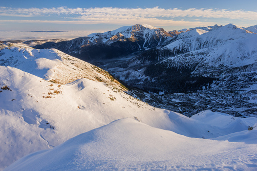 View of Ornak in Western Tatras with snow covered mountain ridges rocky peaks and a clear sky in Tatra County Lesser Poland Voivode Poland. View of Ornak in Western Tatras with snow covered mountain ridges rocky peaks and a clear sky in Tatra County Lesser Poland Voivode Poland.