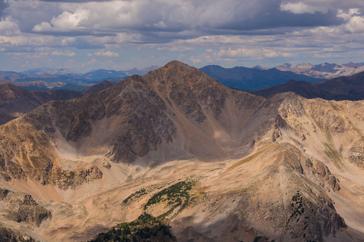 View of Huron Peak from Mount Missouri in the Collegiate Peaks Wilderness with rugged rocky slopes and dramatic clouds in the morning light in Buena Vista Colorado United States.