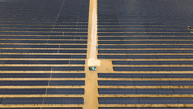 Aerial view of the Eaton Socon solar farm featuring rows of photovoltaic panels a central path and a battery energy storage system in St. Neots England United Kingdom. Aerial view of the Eaton Socon solar farm featuring rows of photovoltaic panels a central path and a battery energy storage system in St. Neots England United Kingdom.