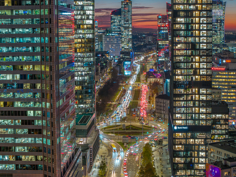 Aerial view of the Warsaw skyline with modern skyscrapers and busy city streets with traffic light trails at dusk in Poland. Aerial view of the Warsaw skyline with modern skyscrapers and busy city streets with traffic light trails at dusk in Poland.