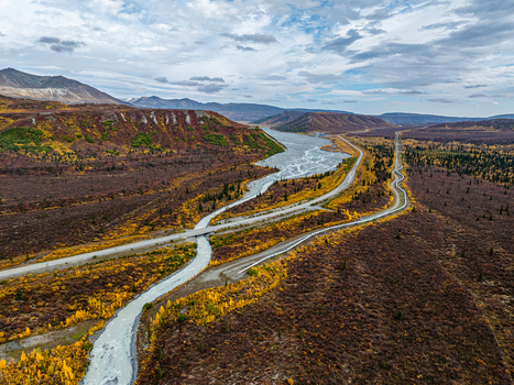 Aerial view of Phelan Creek with its braided riverbed winding through autumn foliage distant mountains and nearby Transalaska Pipeline in Southeast Fairbanks Census Area Alaska United States. Aerial view of Phelan Creek with its braided riverbed winding through autumn foliage distant mountains and nearby Transalaska Pipeline in Southeast Fairbanks Census Area Alaska United States.