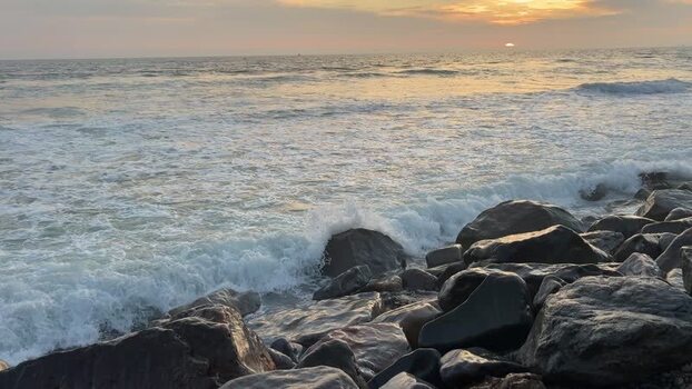 View of ocean waves crashing against rocks at sunset United States. View of ocean waves crashing against rocks at sunset United States.