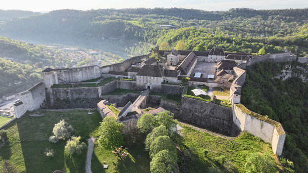 Aerial view of the historic Besancon Citadel with its massive stone fortifications and inner courtyards overlooking the lush green valley in Besancon Bourgogne Franche Comte France. Aerial view of the historic Besancon Citadel with its massive stone fortifications and inner courtyards overlooking the lush green valley in Besancon Bourgogne Franche Comte France.