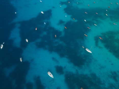 Aerial view of numerous small fishing boats and sailboats anchored in the turquoise waters of the Atlantic Ocean off Santa Maria Sal Cabo Verde. Aerial view of numerous small fishing boats and sailboats anchored in the turquoise waters of the Atlantic Ocean off Santa Maria Sal Cabo Verde.