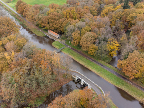 Aerial view of autumn s embrace along serene canals and verdant paths near a quaint building nestled amid colorful trees Tilligte Overijssel Netherlands. Aerial view of autumn s embrace along serene canals and verdant paths near a quaint building nestled amid colorful trees Tilligte Overijssel Netherlands.