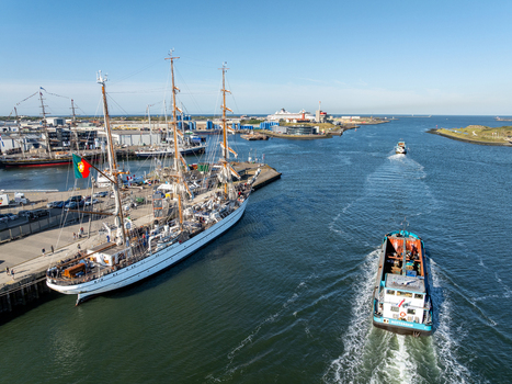 Velsen Netherlands 19 August 2025 Aerial view of a large tall ship the Portuguese NRP Sagres docked at the pier and a barge navigating the harbor waters under a clear blue sky. Velsen Netherlands 19 August 2025 Aerial view of a large tall ship the Portuguese NRP Sagres docked at the pier and a barge navigating the harbor waters under a clear blue sky.