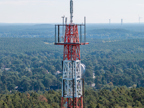 Aerial view of the Muggelberge Antenne radio antenna tower rising above the dense forest landscape in Berlin Berlin Germany. Aerial view of the Muggelberge Antenne radio antenna tower rising above the dense forest landscape in Berlin Berlin Germany.