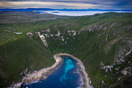 Aerial view of Jimmy Newells Harbour featuring turquoise waters nestled within rugged coastal cliffs and lush green vegetation in Albany WA Australia. Aerial view of Jimmy Newells Harbour featuring turquoise waters nestled within rugged coastal cliffs and lush green vegetation in Albany WA Australia.