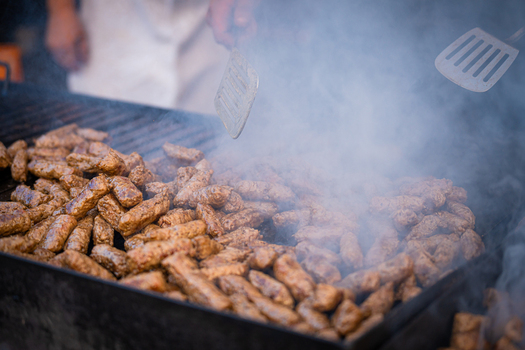 View of sizzling cevapi on a smoky grill tender meat browning under a spatula s touch a feast for the senses fragrant steam rising Pula Istria County Croatia.