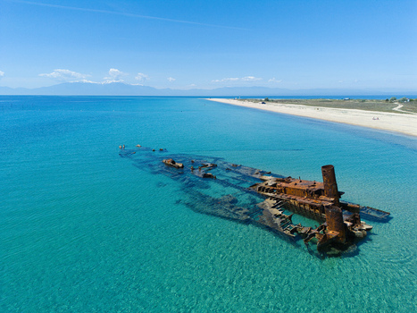 Aerial view of Shipwreck Epanomi in turquoise waters along a sandy coastline under a clear blue sky Epanomi Greece.