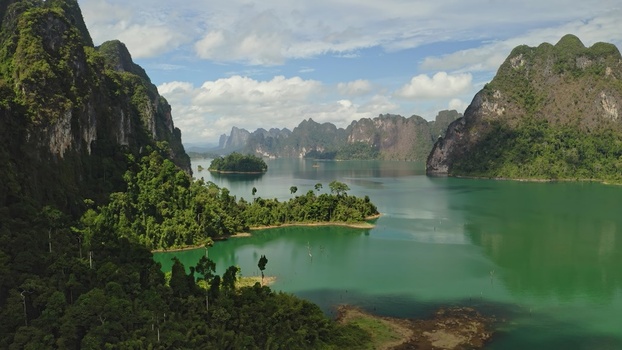Aerial view of Khao Sok National Park featuring limestone karst mountains rising from the emerald green waters of Cheow Lan Lake in Surat Thani Surat Thani Thailand. Aerial view of Khao Sok National Park featuring limestone karst mountains rising from the emerald green waters of Cheow Lan Lake in Surat Thani Surat Thani Thailand.