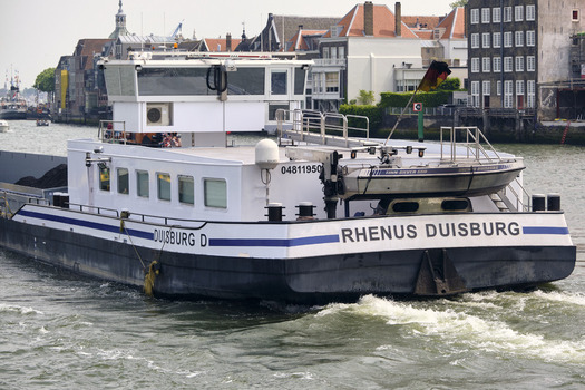 Dordrecht South Holland Netherlands 31 May 2026 View of the Rhenus Duisburg cargo barge navigating the Oude Maas river with historic buildings along the waterfront.
