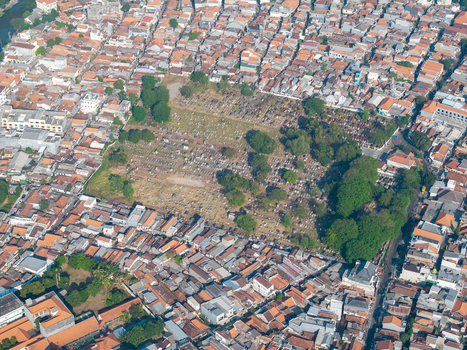 Aerial view of a cemetery surrounded by dense urban housing and lush trees in Surabaya East Java Indonesia. Aerial view of a cemetery surrounded by dense urban housing and lush trees in Surabaya East Java Indonesia.