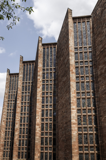View of the red sandstone walls and tall stained glass windows of Coventry Cathedral in Coventry England United Kingdom.