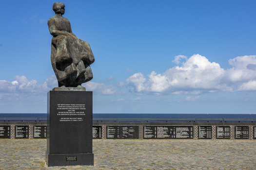 View of the Fisherman s Monument featuring a bronze statue and memorial wall overlooking the sea in Urk Flevoland Netherlands. View of the Fisherman s Monument featuring a bronze statue and memorial wall overlooking the sea in Urk Flevoland Netherlands.