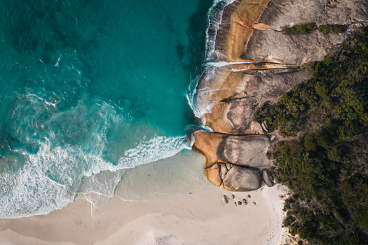 Aerial view of Two Peoples Bay Nature Reserve featuring turquoise water white sand beach and rocky coastline in Albany Western Australia Australia.