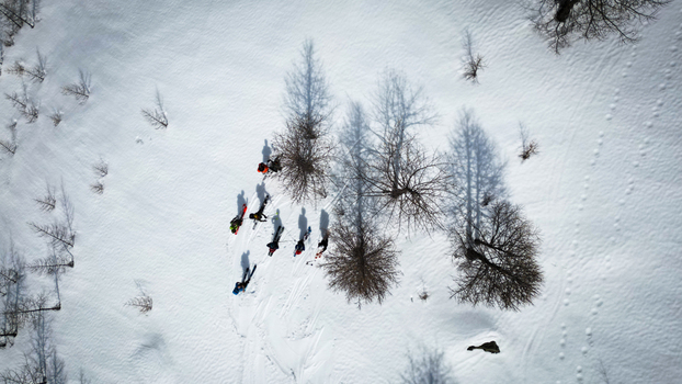 Aerial view of skiers traversing the glistening snow their shadows stretching long across the pristine landscape Arpy Valle d Aosta Italy. Aerial view of skiers traversing the glistening snow their shadows stretching long across the pristine landscape Arpy Valle d Aosta Italy.