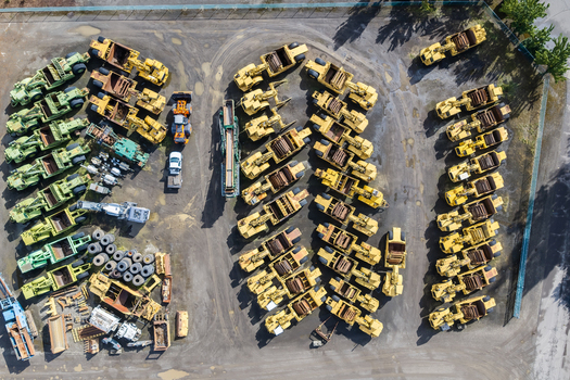 Aerial view of heavy construction machinery and logging equipment parked in neat rows at a storage yard in Woodburn Oregon United States. Aerial view of heavy construction machinery and logging equipment parked in neat rows at a storage yard in Woodburn Oregon United States.