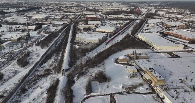 Aerial view of industrial warehouses and a red train in snow United States. Aerial view of industrial warehouses and a red train in snow United States.