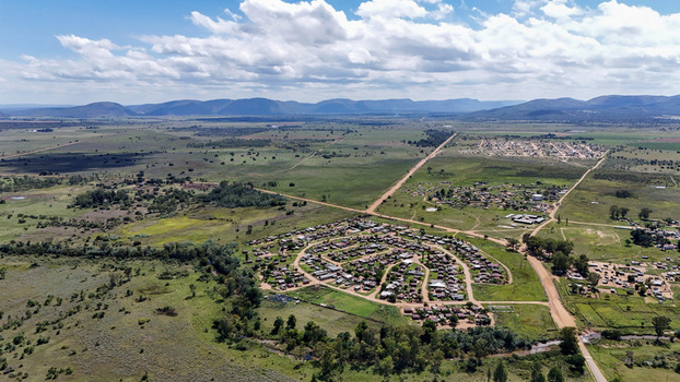Aerial view of the Alma settlement with its circular residential layout surrounded by green plains and distant mountains in Waterberg District Municipality Limpopo South Africa. Aerial view of the Alma settlement with its circular residential layout surrounded by green plains and distant mountains in Waterberg District Municipality Limpopo South Africa.