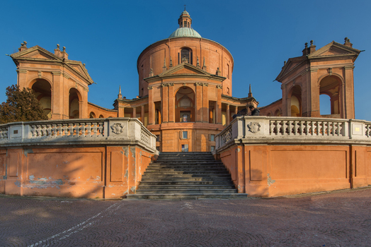 View of Santuario Madonna di San Luca with its terracotta facade symmetrical porticos and stone steps under a clear blue sky Bologna Emilia Romagna Italy. View of Santuario Madonna di San Luca with its terracotta facade symmetrical porticos and stone steps under a clear blue sky Bologna Emilia Romagna Italy.