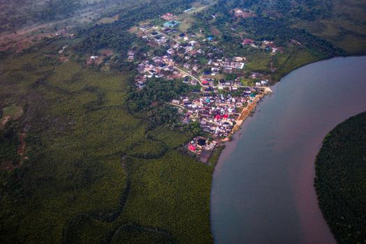 Aerial view of the coastal settlement surrounded by dense mangrove forests and a winding river in Opobo Town Rivers Nigeria. Aerial view of the coastal settlement surrounded by dense mangrove forests and a winding river in Opobo Town Rivers Nigeria.