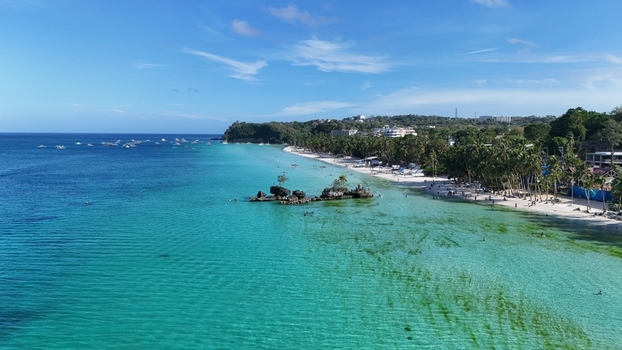Malay Philippines 01 May 2026 Aerial view of Boracay Island featuring Willy s Rock white sand beaches turquoise waters and palm trees under a clear blue sky.