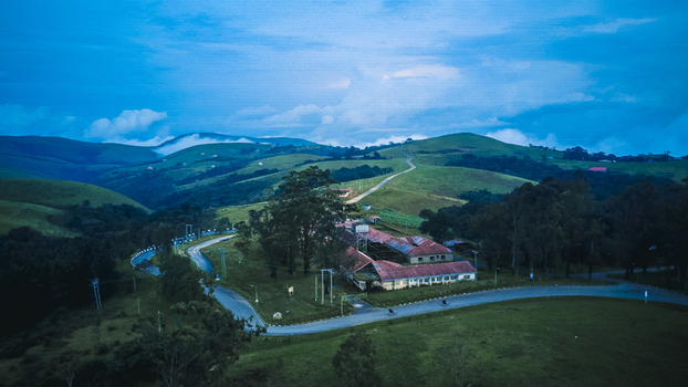 Aerial view of the Obudu Mountain Resort nestled among rolling green hills under a cloudy sky its red roofs contrasting with the lush landscape Obudu Cross River Nigeria.